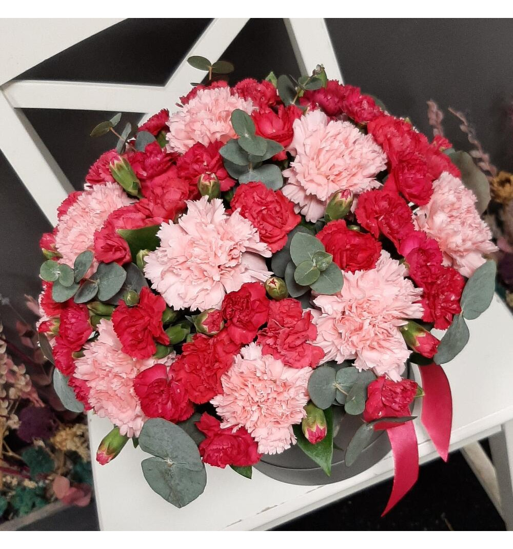 Яркая кустовая и нежно коралловая гвоздика в шляпной коробке